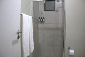 y baño con ducha y toallas blancas. en Cozy Studio in Midrand en Midrand