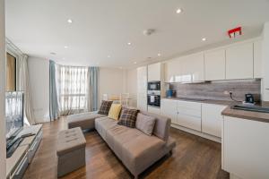 a living room with a couch and a kitchen at Spacious Modern 1-Bedroom Flat in Central London in London