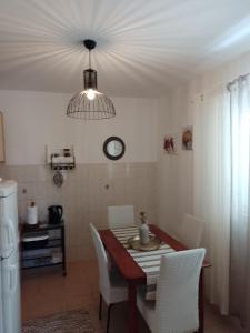 a dining room with a table and a clock on the wall at Apartman Mare in Drvenik