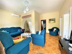 ein Wohnzimmer mit blauen Sofas und einem Tisch in der Unterkunft Villa Allegri in Vlorë