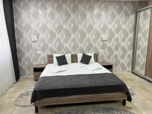 um quarto com uma cama e uma parede em Motel Xameleon em Voznesensk