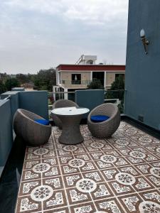 a patio with a table and chairs on a roof at A Creation Farm Stay in Shamshabad