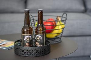 - deux bouteilles de bière assises sur une table avec une corbeille de fruits dans l'établissement Industrie Loft 1902 - Gratis Parken - Zentral, à Wilhelmshaven