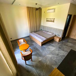 a bedroom with a bed and a table and chairs at A Creation Farm Stay in Shamshabad