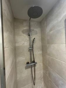 y baño con ducha con cabezal de ducha. en Fantastic house, great location en Laindon