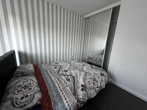 Un dormitorio con una cama con una manta. en Fantastic house, great location en Laindon