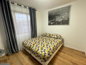 Un dormitorio con una cama y una ventana en Appartement au Pied du Metro Mairie de Clichy L13, en Clichy