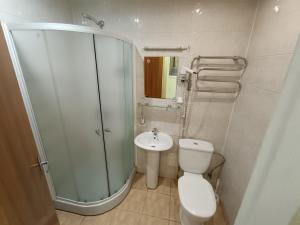 a bathroom with a shower and a toilet and a sink at viešbutis Jurbarkas in Jurbarkas