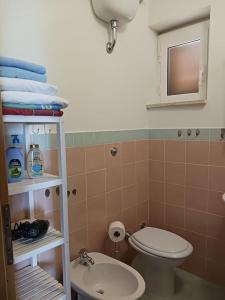 a bathroom with a toilet and a sink and towels at Casa vista mare in San Nicola Arcella