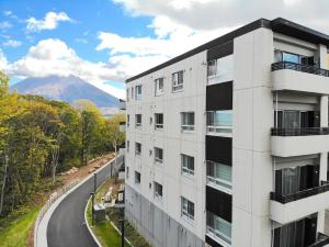 an apartment building with a mountain in the background at The Freshwater in Kutchan