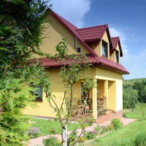 uma casa amarela com um telhado vermelho em Górski Przystanek em Mizerna