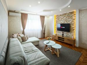 a living room with a couch and a tv at Apartman Julija in Donji Milanovac