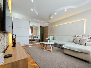 uma sala de estar com um sofá e uma mesa em Apartman Julija em Donji Milanovac