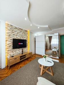 a living room with a tv on a brick wall at Apartman Julija in Donji Milanovac