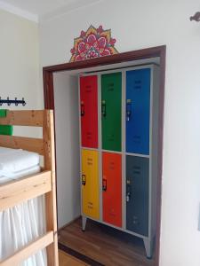 a locker with colorful doors next to a bed at Paz & Amor Guest House - Peace & Love in Nazaré