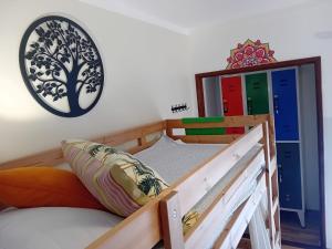 1 dormitorio con litera y reloj en la pared en Paz & Amor Guest House - Peace & Love, en Nazaré