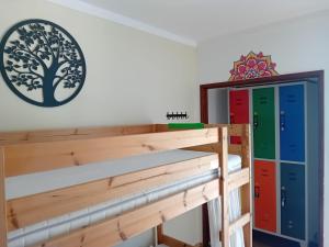 une étagère en bois avec un arbre sur le mur dans l'établissement Paz & Amor Guest House - Peace & Love, à Nazaré