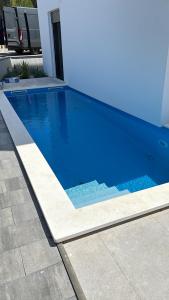 a large blue swimming pool next to a house at Villa Nika in Bibinje