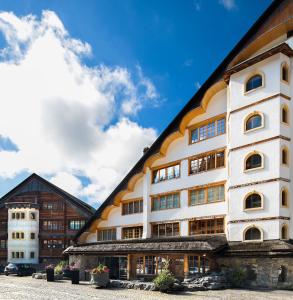 a white building with a black roof at Hotel Etrier in Crans-Montana