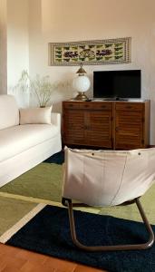 een woonkamer met een bank en een tv bij Kirù Lovely Home - Villa Su Cuile, Cala Ginepro in Monte Petrosu