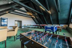 a ping pong table in a room with tables and chairs at Hotel RYSY in Tatranska Strba