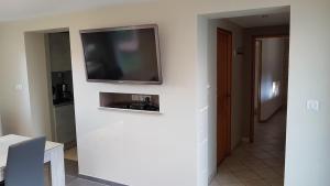 ein Wohnzimmer mit einem Fernseher an der Wand in der Unterkunft gite cocoon neuf proche GERARDMER in Vienville