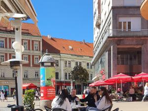 un grupo de personas sentadas en una mesa en una calle de la ciudad en B&B Centar en Zagreb