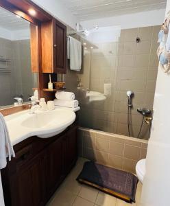een badkamer met een wastafel en een douche bij Pasithea House in Ioulida