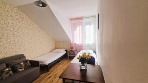 uma sala de estar com um sofá e uma mesa com flores em Apartament w centrum Piwnicznej em Piwniczna