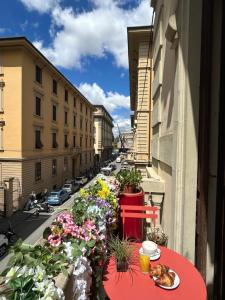 a cat sitting on a table on a balcony with flowers at Hotel Brooklyn - ex Hotel Lombardi in Florence