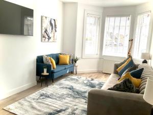 sala de estar con sofá azul y alfombra en Harling House en Prestwick