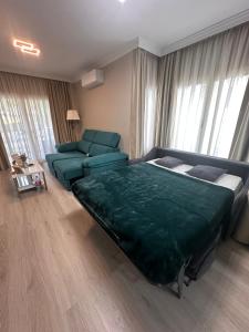 - une chambre avec un lit vert et un canapé dans l'établissement APARTAMENTO CERCA AL MAR, à Benalmádena