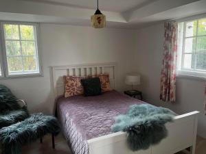 um quarto com uma cama com almofadas peludas em Rosenlund Gods - kælder B&B em Sakskøbing