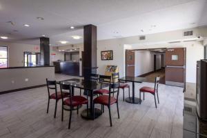 Westwood的住宿－High Point Inn & Suites，一间带桌子和红色椅子的用餐室