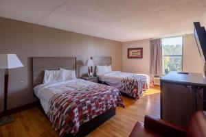 Westwood的住宿－High Point Inn & Suites，酒店客房设有两张床和窗户。