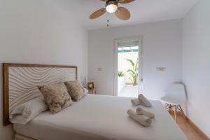 - une chambre avec un grand lit blanc et un ventilateur de plafond dans l'établissement Villa Mimosas, à Altea