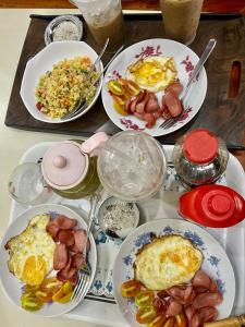 a table with plates of breakfast food on it at Cherry Homestay - Hoàng Đế motel in Chau Doc