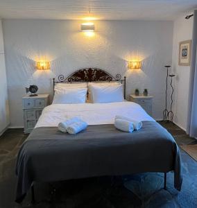 a bedroom with a large bed with two towels on it at Pasithea House in Ioulis