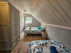 Schlafzimmer im Dachgeschoss mit 2 Betten und einem Fenster in der Unterkunft Kominkówka in Brenna