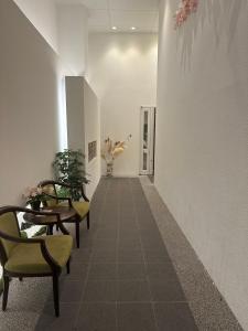 un couloir avec des chaises et des tables dans un bâtiment dans l'établissement 難波民泊501, à Osaka