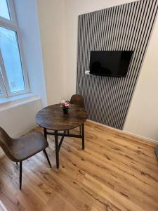 ウィーンにあるSchöne Wohnung im Zentrum Wienのテーブル、椅子、テレビが備わる客室です。