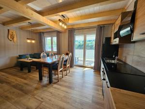 a kitchen and dining room with a table and chairs at Kominkówka in Brenna +17 photos