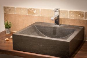 - un lavabo noir dans la salle de bains avec un robinet sur un comptoir dans l'établissement B&B Maison d'hôte et gite Mas d'Eymard, à Arles
