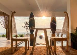 two surfboards sitting on a table in front of a window at Baan Sailboat Beach Kohlarn in Ban Kraek