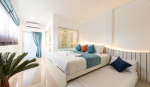 a white bedroom with a bed and a window at Baan Sailboat Beach Kohlarn in Ko Larn +54 photos