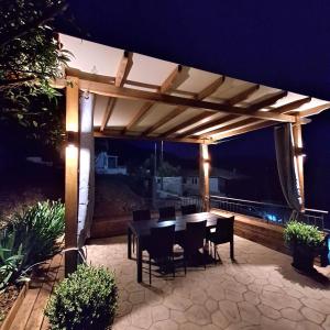 a patio with a table and chairs at night at Philoxenia Home in Áyios Pétros