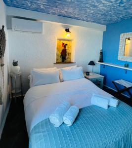 een blauwe slaapkamer met een bed met twee handdoeken erop bij Pasithea House in Ioulida