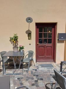 a red door and a table and chairs in front of a door at 30qm Studio Rosenheimer Innenstadt in Rosenheim