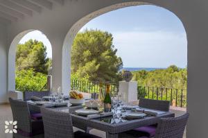 a dining room with a table and chairs on a balcony at Villa Corasol by Abahana Villas in Teulada