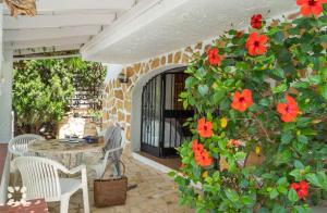 a patio with a table and red flowers at Villa Corasol by Abahana Villas in Teulada